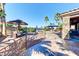 Stunning backyard pool area featuring luxurious seating, manicured landscaping, palm trees and a covered patio at 8209 Chapelle Ct, Las Vegas, NV 89131