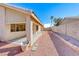 Long backyard with a covered patio, desert landscaping, and a tall block fence at 1035 Dodger Blue Ave, Las Vegas, NV 89123