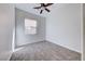 A simple carpeted bedroom is well-lit by a window and overhead ceiling fan at 1035 Dodger Blue Ave, Las Vegas, NV 89123