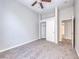 Neutral bedroom features a closet with sliding doors, ceiling fan, and open doorway to tiled bathroom at 1035 Dodger Blue Ave, Las Vegas, NV 89123