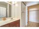 Well-lit bathroom featuring a vanity with sink, a mirrored cabinet, and a closet for storage at 10431 Kitty Joyce Ave, Las Vegas, NV 89129