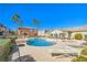 Community pool and lounge area surrounded by lush greenery and palm trees on a clear, sunny day at 10431 Kitty Joyce Ave, Las Vegas, NV 89129