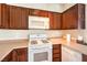 Efficient kitchen featuring a gas range, microwave, and dark wooden cabinetry at 10431 Kitty Joyce Ave, Las Vegas, NV 89129