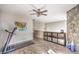 A spacious loft featuring wood floors and a stone accent wall, illuminated by soft, natural light at 10431 Kitty Joyce Ave, Las Vegas, NV 89129