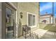 A patio with a small table and an outdoor light fixture on the stucco wall at 10431 Kitty Joyce Ave, Las Vegas, NV 89129