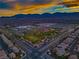 Vibrant aerial view of a well-planned community showcasing homes, green spaces, and mountain views at sunset at 10725 Wrigley Field Ave, Las Vegas, NV 89166