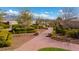 Brick path with white arbor leading through a lush community garden at 10725 Wrigley Field Ave, Las Vegas, NV 89166