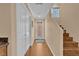 Hallway with wood floors leading to staircase, neutral decor, and natural light at 10725 Wrigley Field Ave, Las Vegas, NV 89166