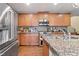 Spacious kitchen with stainless steel appliances, wood cabinets, and granite countertops at 10725 Wrigley Field Ave, Las Vegas, NV 89166