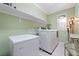 Bright laundry room with built-in shelving, washer, dryer, and ample storage space at 10725 Wrigley Field Ave, Las Vegas, NV 89166