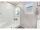 This is a bathroom with a glass shower, white subway tiles and bright window at 10922 Cambridge Lakes Ave, Las Vegas, NV 89166