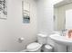 Half bath featuring a pedestal sink, decorative textured wall, and modern fixtures at 10922 Cambridge Lakes Ave, Las Vegas, NV 89166