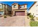 Charming two-story home with a two-car garage and brick driveway, set against a bright blue sky at 10922 Cambridge Lakes Ave, Las Vegas, NV 89166