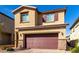 Exterior of a two-story home featuring brick accents, complemented by a dark-colored two-car garage door at 10922 Cambridge Lakes Ave, Las Vegas, NV 89166