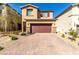 Two-story home featuring a brick driveway and a two-car garage at 10922 Cambridge Lakes Ave, Las Vegas, NV 89166