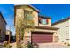 Well-maintained two-story home showcasing a two-car garage with a brick driveway and manicured landscaping at 10922 Cambridge Lakes Ave, Las Vegas, NV 89166