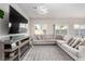 Living room with a large sectional sofa, modern lighting, and a sleek entertainment center with fireplace at 10922 Cambridge Lakes Ave, Las Vegas, NV 89166