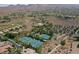 A stunning aerial shot showcases a community featuring tennis courts and a pool, nestled within a desert landscape at 11 Belfair Ct, Henderson, NV 89052