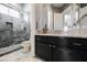 Modern bathroom with gray tiled shower and black vanity with marble countertop at 11 Belfair Ct, Henderson, NV 89052