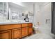 Bright bathroom featuring double sinks, a wooden vanity and a shower-tub combo at 11 Belfair Ct, Henderson, NV 89052