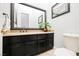 Neutral-toned powder room featuring a dark vanity, stone countertop, and a decorative mirror at 11 Belfair Ct, Henderson, NV 89052