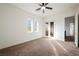 Bright bedroom boasts neutral carpet, ceiling fan, and a glass door to a balcony at 11 Belfair Ct, Henderson, NV 89052