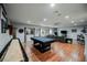 Spacious game room with a pool table, shuffleboard, and gray sectional sofa at 11 Belfair Ct, Henderson, NV 89052