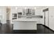 Bright, white kitchen with a large island, stainless steel appliances, and dark hardwood floors at 11 Belfair Ct, Henderson, NV 89052