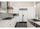 Modern kitchen featuring stainless steel appliances, white cabinetry, and sleek dark wood floors at 11 Belfair Ct, Henderson, NV 89052