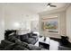 Inviting living room featuring a plush gray sofa, dark floors, and bright natural light at 11 Belfair Ct, Henderson, NV 89052