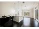 Bright and airy living room with a piano, sleek dark wood floors and modern fixtures at 11 Belfair Ct, Henderson, NV 89052