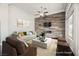 Staged living room with a white sofa, fireplace, wood accent wall, and a bright window at 11 Belfair Ct, Henderson, NV 89052