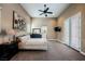 Spacious main bedroom featuring neutral tones, carpeted floors, ceiling fan, and en suite bathroom at 11 Belfair Ct, Henderson, NV 89052