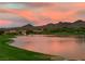 Scenic sunset view over the pond and lush golf course, surrounded by mature trees and mountains at 11 Belfair Ct, Henderson, NV 89052