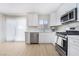 Bright kitchen featuring white cabinets, stainless steel appliances and sliding glass door at 1105 Pawnee Ln, Henderson, NV 89015