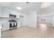 Bright kitchen features stainless steel appliances and white cabinetry that opens to the living room at 1105 Pawnee Ln, Henderson, NV 89015