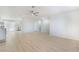 Bright living room featuring wood-look floors, ceiling fan, and an open layout to the kitchen at 1105 Pawnee Ln, Henderson, NV 89015