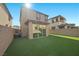 A well-maintained backyard with artificial turf, featuring a covered patio and privacy walls at 12525 Lylan Ridge St, Las Vegas, NV 89138