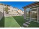 Backyard features an artificial lawn, retaining wall, multiple levels, and outdoor lounge area at 12525 Lylan Ridge St, Las Vegas, NV 89138