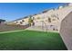 Backyard features an artificial lawn, retaining wall, multiple levels, and outdoor lounge area at 12525 Lylan Ridge St, Las Vegas, NV 89138