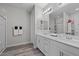 Modern bathroom with double sink vanity, white cabinets, large mirror, and glass-enclosed shower at 12525 Lylan Ridge St, Las Vegas, NV 89138