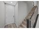 Bright entryway featuring modern white door and staircase with dark wood trim and metal railing at 12525 Lylan Ridge St, Las Vegas, NV 89138