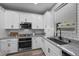 Modern kitchen showcasing stainless steel appliances, granite countertops, and sleek white cabinets at 12525 Lylan Ridge St, Las Vegas, NV 89138