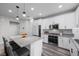 Modern kitchen with white cabinets, stainless steel appliances, granite countertops, and gray wood flooring at 12525 Lylan Ridge St, Las Vegas, NV 89138