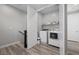 Modern laundry room with side by side washer and dryer, gray walls, and open shelving with laundry supplies at 12525 Lylan Ridge St, Las Vegas, NV 89138