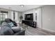 Bright living room featuring natural lighting, a modern entertainment center, sleek couches, and hardwood floors at 12525 Lylan Ridge St, Las Vegas, NV 89138