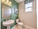 Stylish powder room featuring a pedestal sink, modern fixtures, and fresh green accent wall at 1918 Molly Brook Dr # Lot 5, North Las Vegas, NV 89084