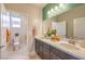 Well lit bathroom featuring double sinks, modern vanity, quartz counters, and a toilet room at 1918 Molly Brook Dr # Lot 5, North Las Vegas, NV 89084