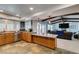 Bright kitchen with granite countertops, stone flooring, wood cabinets, and an open plan layout to the living room at 2246 Almart Cir, Henderson, NV 89014