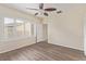 Bedroom with wood floors, ceiling fan, window with shutters, and ensuite bath at 2404 Garganey Ave, North Las Vegas, NV 89084